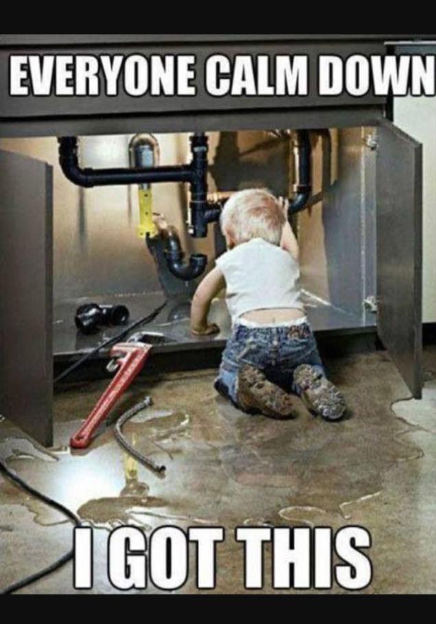 A small child pretending to fix the plumbing under the sink with the caption 'I got this'